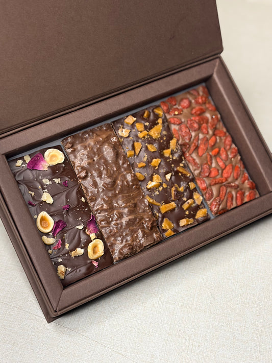 Barks in a Box – open gift box of chocolate barks topped with nuts, rose petals and berries